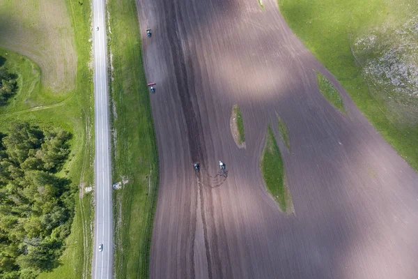 Aerial view of a farm tractor in a field during plowing of land