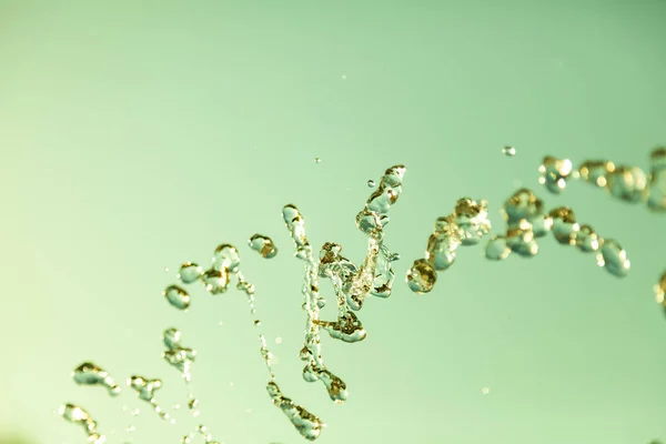 Water droplets frozen in the air with splashes and chain bubbles