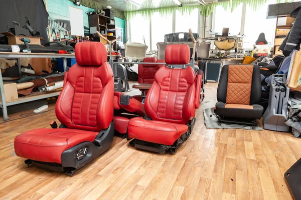 Four sport seats with red leather trim, located on the floor in