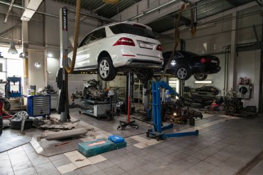  Onarım için bir asansör de yükseltilmiş açık bir başlık ile iki ikinci el araba 