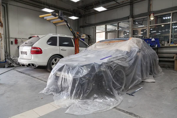 Un coche sedán blusa está completamente cubierto de película y grifo adhesivo — Foto de Stock