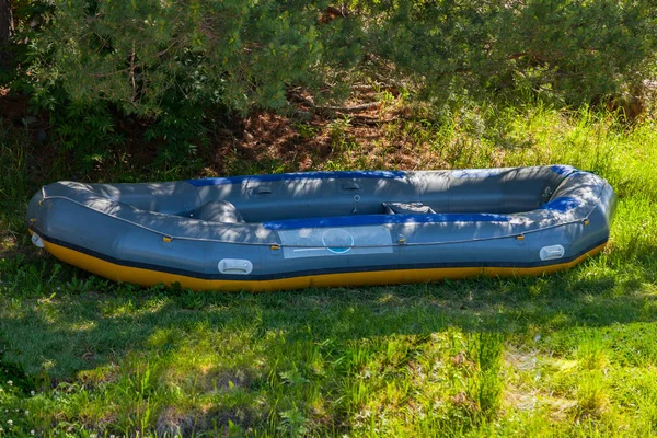 Ağaçların altında gölgede büyük şişme rafting tekne yakın — Stok fotoğraf