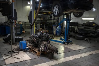 Bir sedan araba onarım için bir asansör üzerinde kaldırdı ve altında müstakil