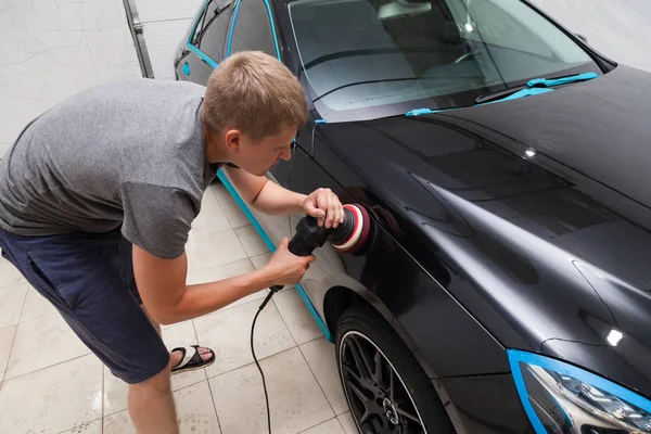 The polisher polishes the body of the vehicle with special wax t