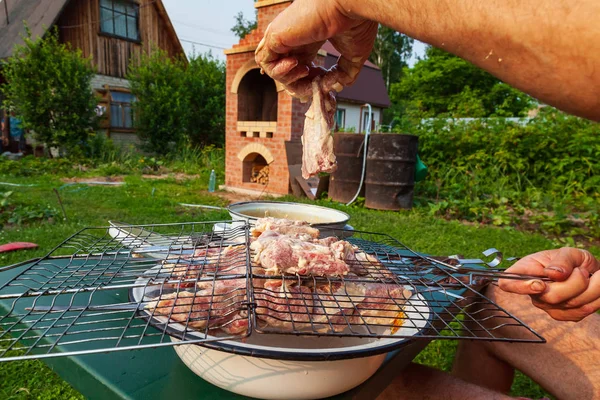 Nahaufnahme an der Hand eines Mannes, der Fleisch in einer Marinade mit — Stockfoto