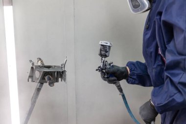 Tulum ve eldiven bir erkek işçi bir sprey tabancası ile boya bir p