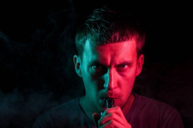 Genç bir esmer adam elinde tutar ve bir electroni üzerinde sürükler