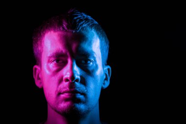 Pembe ve mavi ile aydınlatılmış tam yüz lü bir adamın portresi