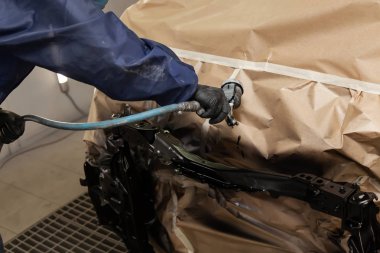 Tulum ve eldiven bir erkek işçi bir sprey tabancası ile boya bir f