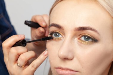 Makyaj sanatçısı altın ve gr ile oryantal tarzı makyaj koyar