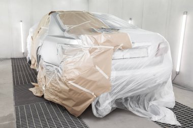 Büyük bir gümüş sedan araba tamamen kağıt ve yapıştırıcı kaplıdır