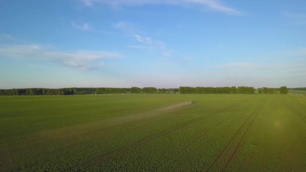 Flygbild Lantbrukstraktor Ett Grönt Fält Sprutning Och Bevattning Med Bekämpningsmedel — Stockvideo