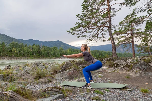 Mädchen kauert beim Training im Altai in der Natur — Stockfoto