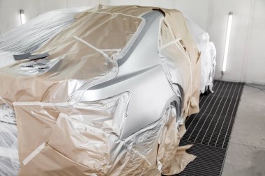 Büyük bir gümüş sedan araba tamamen kağıt ve yapıştırıcı kaplıdır