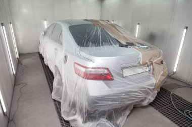 Büyük bir gümüş sedan araba tamamen kağıt ve yapıştırıcı kaplıdır