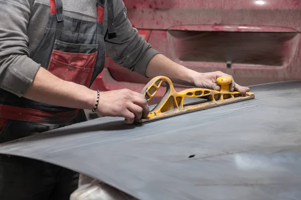 Man worker preparing for painting a car element using emery send — Stock Photo, Image