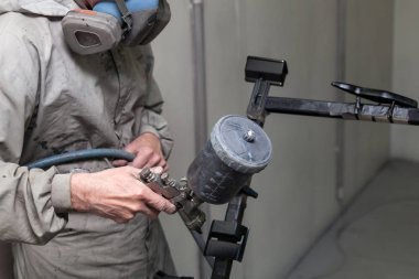 Tulum ve maske boyalar bir erkek işçi bir sprey tabancası par ile