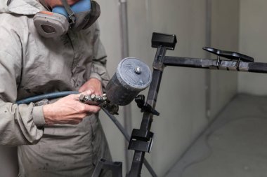 Tulum ve maske boyalar bir erkek işçi bir sprey tabancası par ile