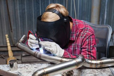 Damalı kırmızı gömlek li genç adam kaynak paslanmaz bir stee