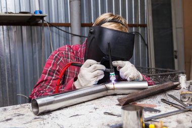 Damalı kırmızı gömlek li genç adam kaynak paslanmaz bir stee