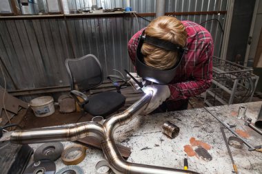 Damalı kırmızı gömlek li genç adam kaynak paslanmaz bir stee