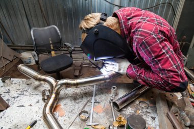 Damalı kırmızı gömlek li genç adam kaynak paslanmaz bir stee