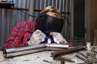 Damalı kırmızı gömlek li genç adam kaynak paslanmaz bir stee