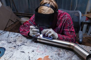 Damalı kırmızı gömlek li genç adam kaynak paslanmaz bir stee