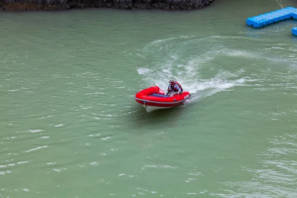 Luftaufnahme eines roten Gummimotorbootes, das auf einem grünen Fluss segelt — Stockfoto