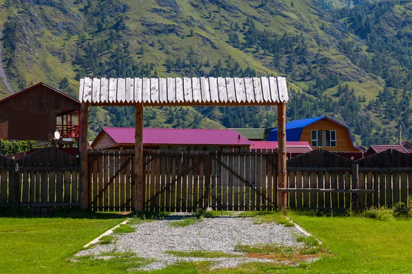 Wooden gate with a fence and a canopy from the rain on a country