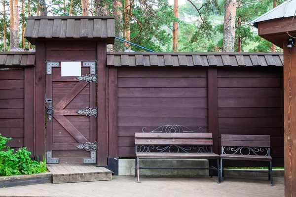 Gros plan sur une porte en bois brun avec des motifs charnières en fer forgé — Photo