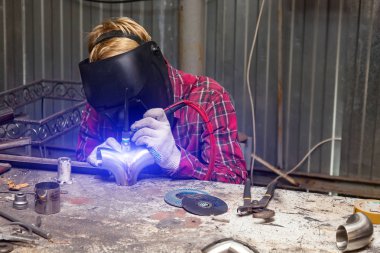 Damalı kırmızı gömlek li genç adam kaynak paslanmaz bir stee