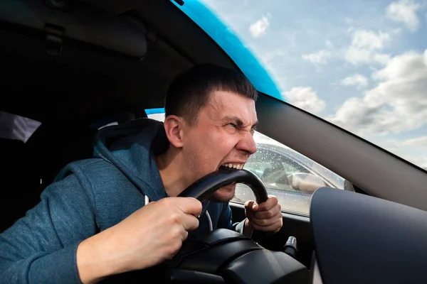 Niezrównoważony, Goosey człowiek gryzie kierownicy samochodu od gniewu — Zdjęcie stockowe