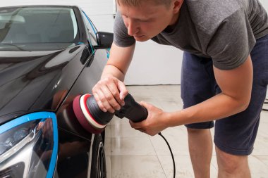 Yakından görmek için bir araç tutan bir erkek işçinin ellerinde