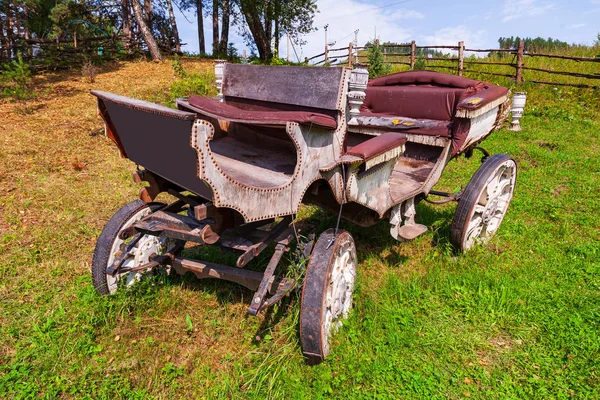 Un viejo carruaje de madera con ruedas grandes sin caballo o — Foto de Stock