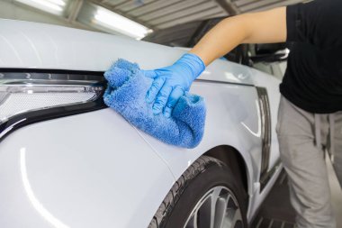 beyaz bir c siler mavi mikrofiber bez ile bir erkek temizleyici