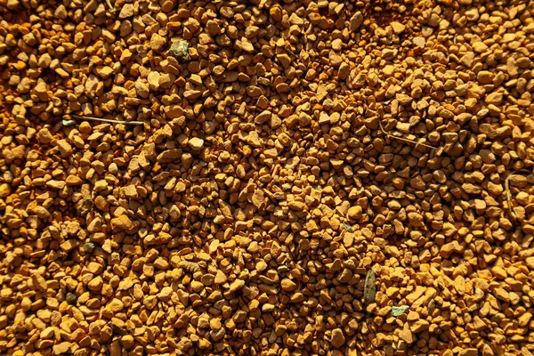 Fondo de pequeñas piedras decorativas amarillas que yacen en el suelo — Foto de Stock