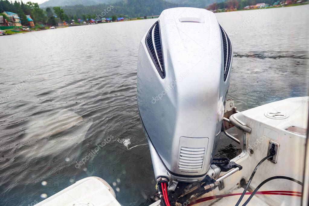 Motor boat engine while sailing on a lake with waves of water fr