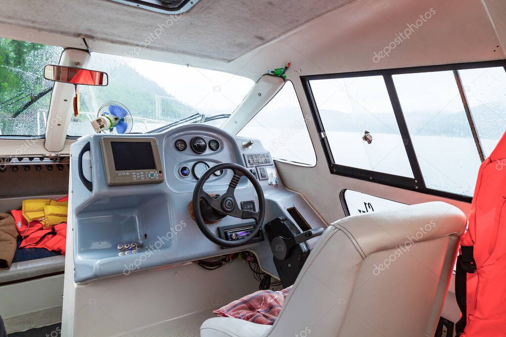 Cabin of a motor boat with an inside view with a steering wheel 