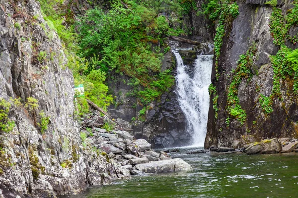 A picturesque natural place with a waterfall flowing from the Al — Stock Photo, Image