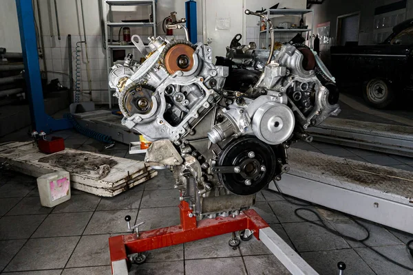 자동차 지상에 설치하기 위해 크레인에 장착 된 V8 엔진을 사용하였다 — 스톡 사진