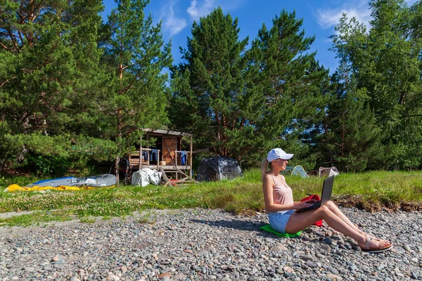 Молодая красивая блондинка в белой кепке и джинсовых шортах — стоковое фото