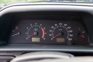 Beyaz sayılar, işaretler ve kırmızı seviyeli oklarla siyah bir zemin üzerinde hız, basınç ve sıcaklık ölçmek için sensörleri olan bir kontrol panelinin yakın plan görüntüsü.