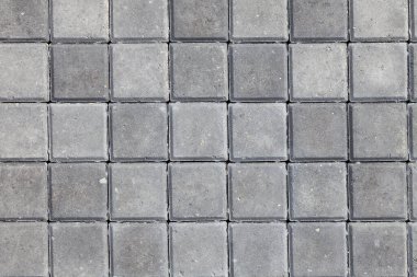 Kare döşeme taşlarından gri rengin arkaplanı ve dokusu. Yolların ve yayaların dekoru.