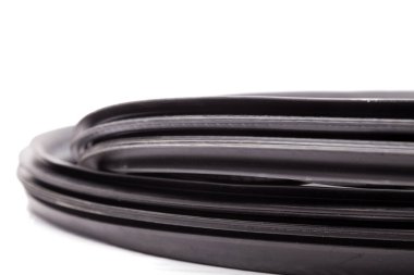 Siyah yalıtım malzemelerinden oluşan bir skein, arabanın içindeki ısı kaybı ve nem girmesini önlemek için lastik conta araba servisinde satılık bir fotoğraf stüdyosunun beyaz arka planında..