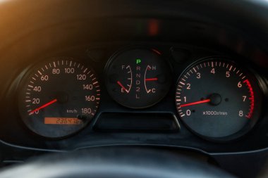 Araba gösterge paneli geceleri kırmızı oklarla aydınlatılıyor. Hız göstergesi, takometre ve diğer aletlerle arabanın durumunu modern bir şekilde izole edilmiş siyah bir arka planda izlemek için..