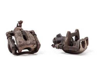 Bir fotoğraf stüdyosunun beyaz arka planında pasla kaplı eski bir çift metal fren kalibresi. Araba servisinde yedek parça ya da oto ayrıştırma bölümünde satılık..