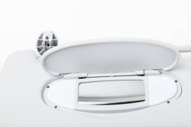 Bir fotoğraf stüdyosunun beyaz arka planında açık gri plastikten yapılmış bir aynası olan güneşlik. Araba servisinde ya da otomatik sökme işleminde yedek parça ya da satışta.