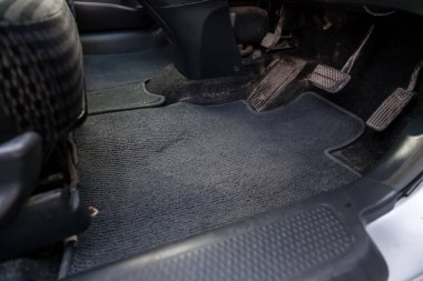 Kirli araba halısı, kuru temizlemeden önce gaz, fren ve debriyaj pedallarıyla birlikte koyu mavi kumaştan yapılmış..