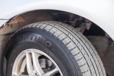 Novosibirsk, Rusya - 08.05.2020: Tozlu bir yol diski üzerinde kullanılmış beyaz bir araba tekerleğinin yakın çekimi. Bir araba tamirhanesinde mevsimlik tekerlek değişimi.